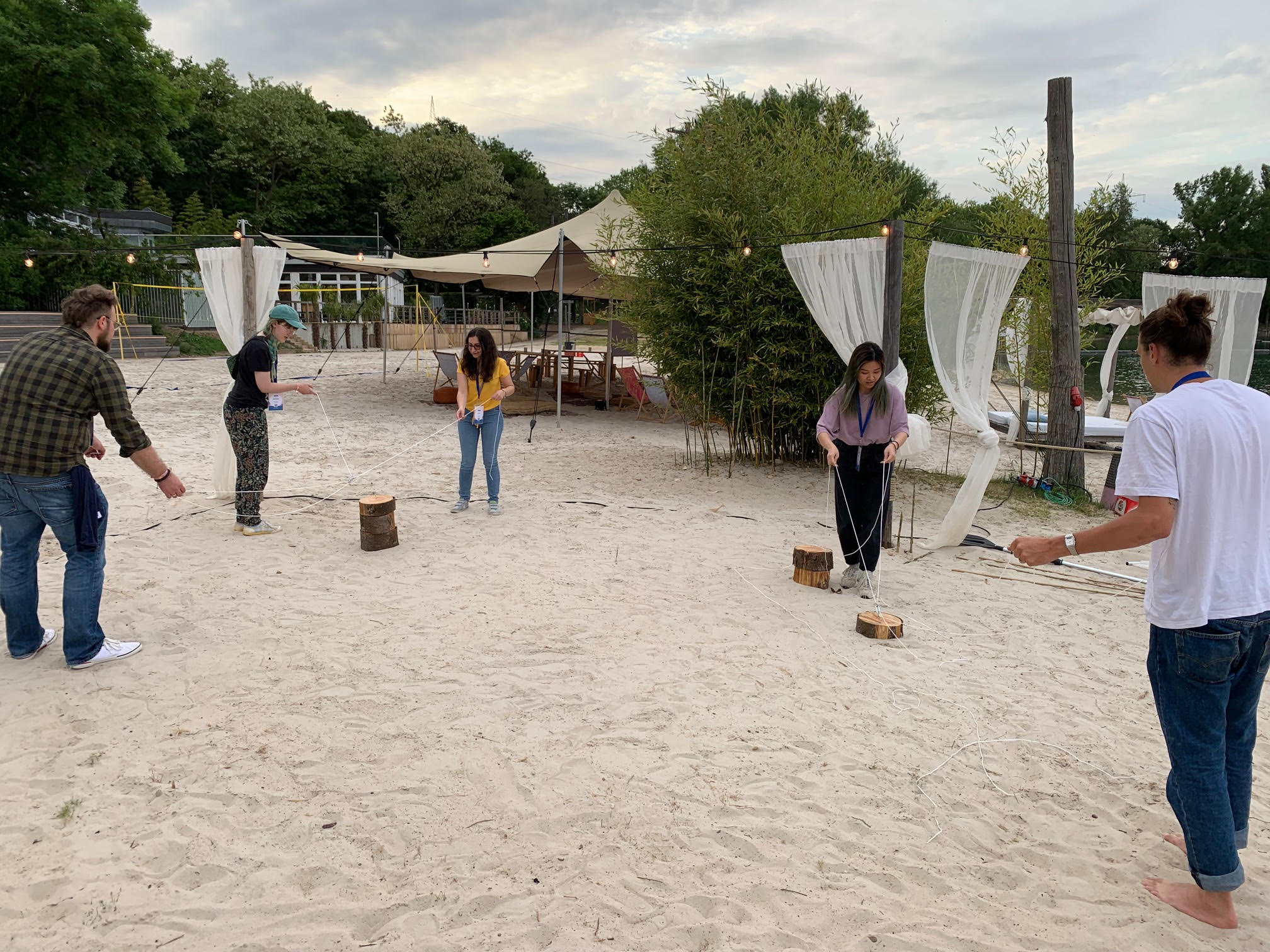 group of people playing games in the sand
